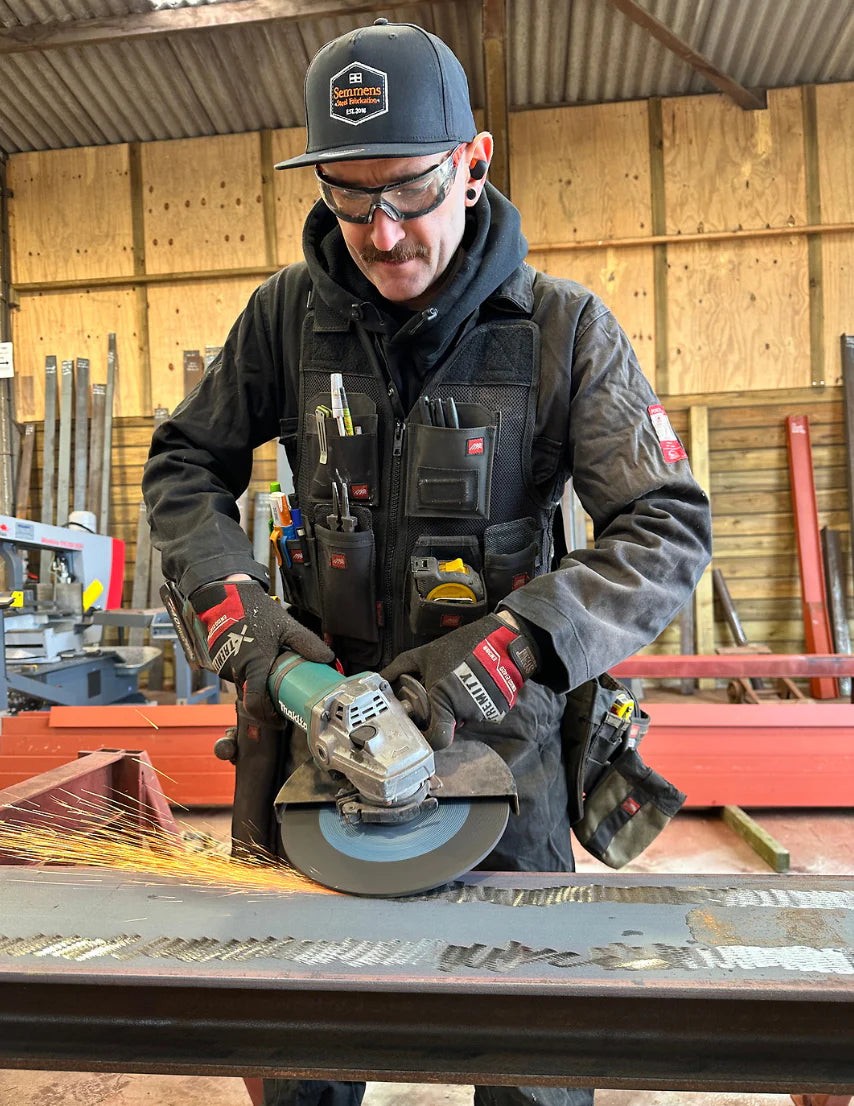 "A professional wearing the 701 Tool Vest on a job site, fully equipped."